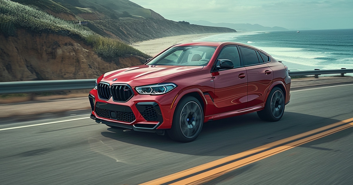 Red BMW X6 driving on a coast highway