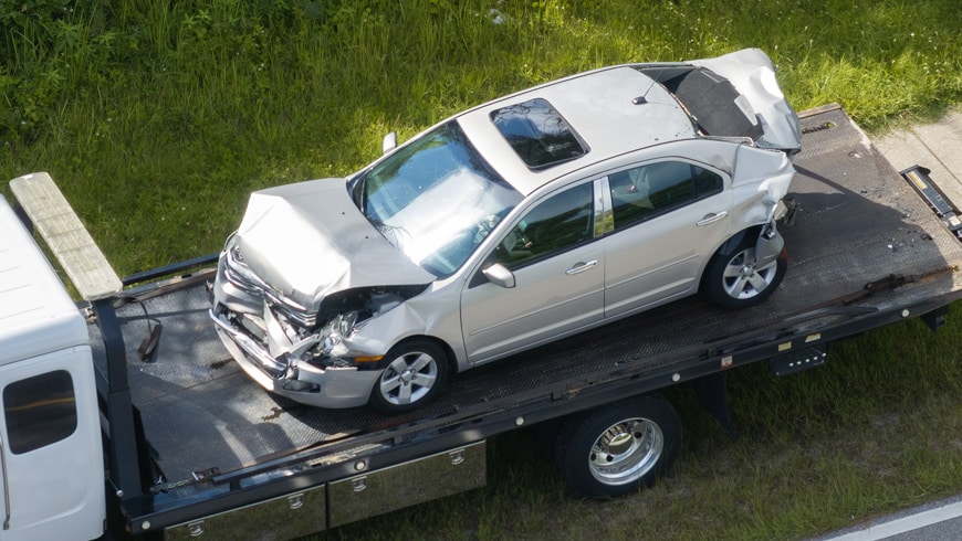 total loss car on flatbed tow truck