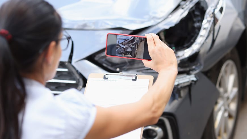woman documenting damage to vehicle