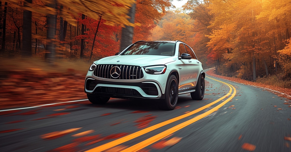 White Mercedes-Benz AMG GLC43 driving fast on a fall day